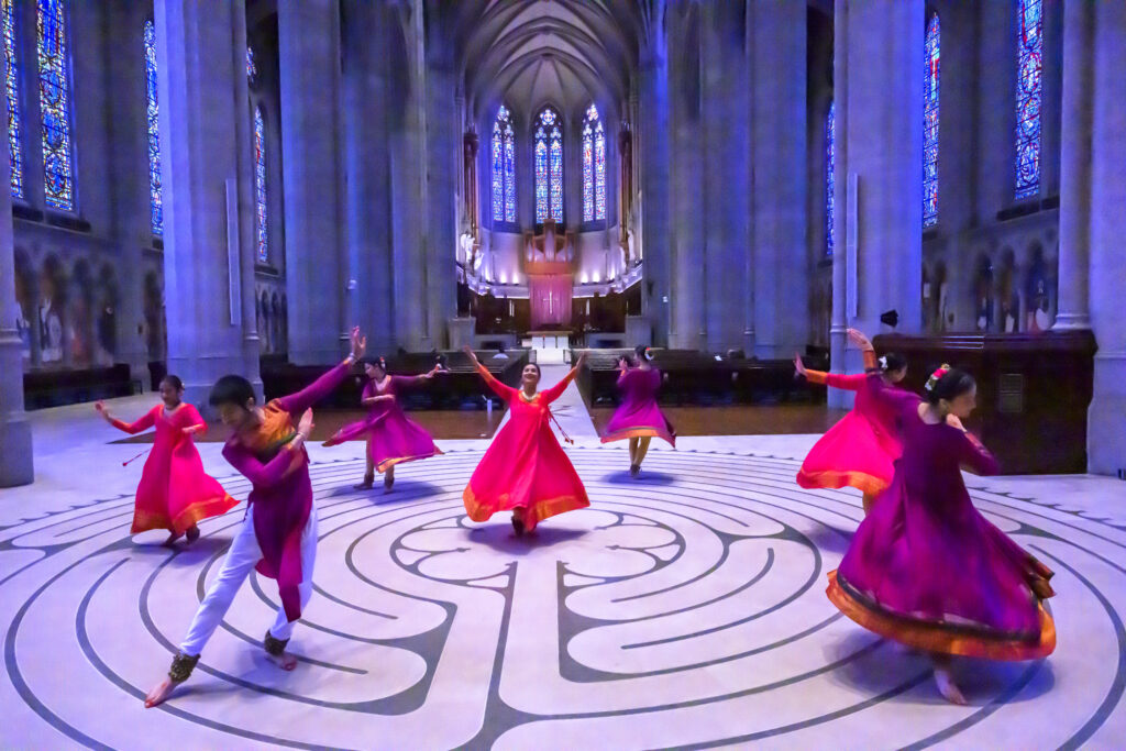 Dancers perform inside a grand cathedral room